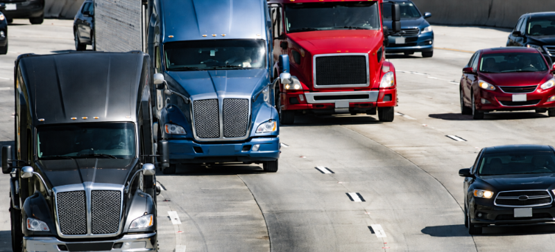 Trucks and cars navigating highway congestion.